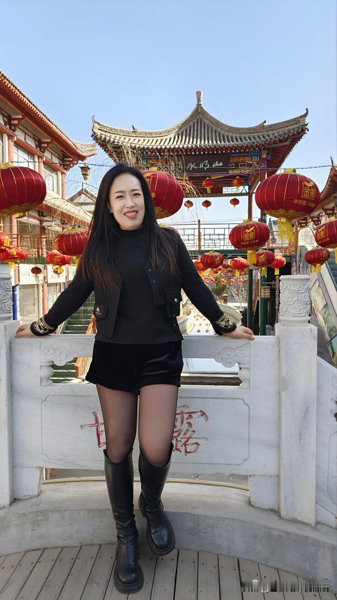 红灯笼坠满古檐，风掠过雕栏时，把新春的热闹与衣袂的飒，都揉进了蓝天下的剪影里。