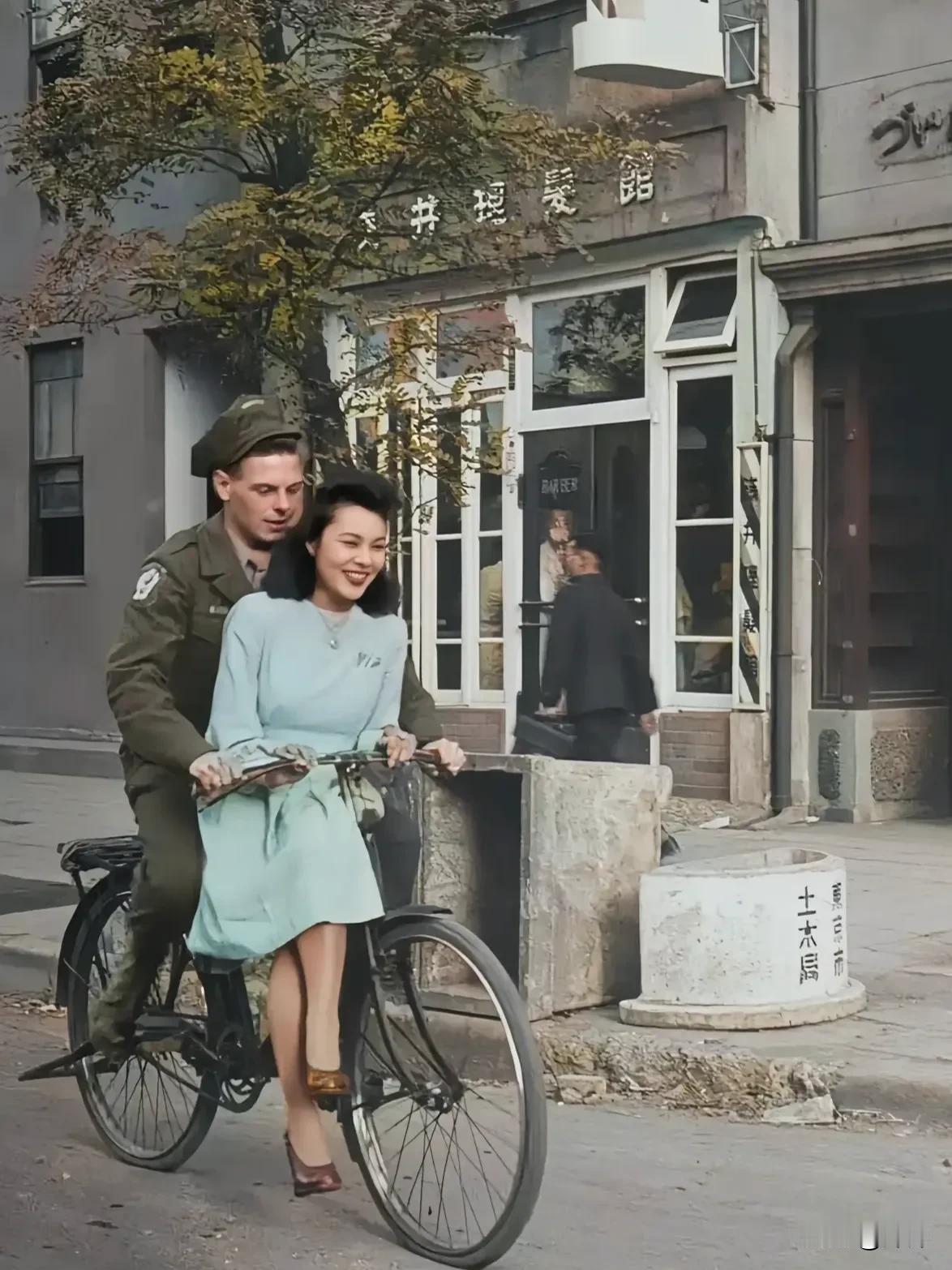 这张图片展示了一名美国士兵和一名女子在日本街头骑自行车的场景。
 
第二次世界大