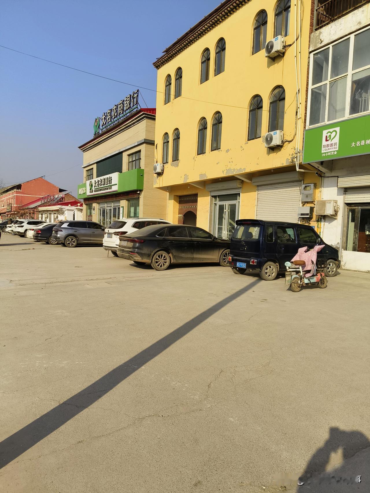 晒图笔记大赛 小镇街景：宁静的午后，阳光洒在黄墙绿瓦上，车流缓缓驶过，生活如此惬