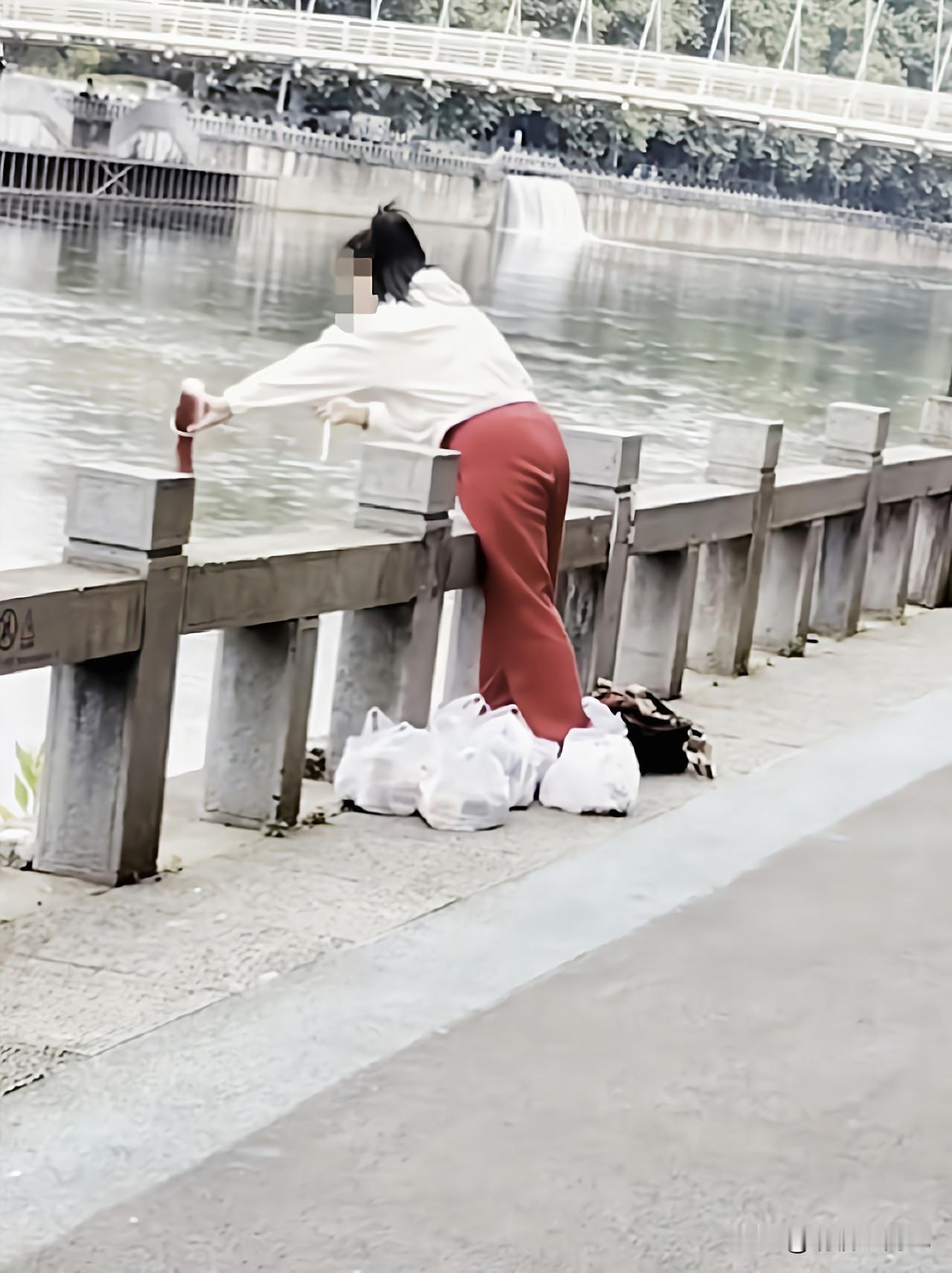 简直荒唐，贵州贵阳河滨公园南明河畔，一名女子提着6袋奶茶，正做着让人摸不着头脑的