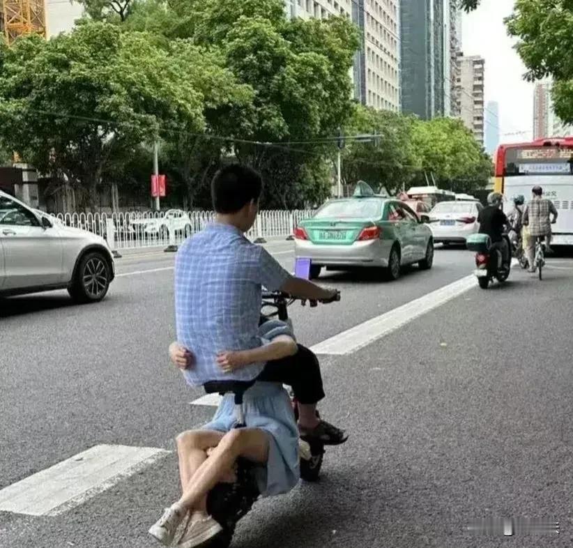 这样骑电动车带人，你看见过吗？男孩骑着电动车带着女朋友，奇怪的是，女孩并没有坐在