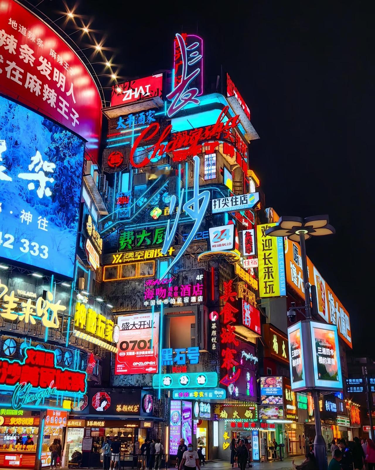把长沙的夜揉进镜头里，霓虹招牌在老巷的砖石上叠成赛博朋克的梦。“欢迎长来玩”的灯