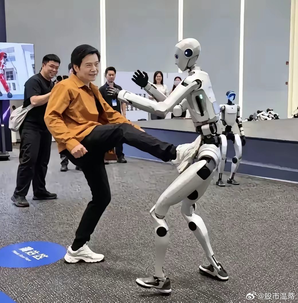 雷军9月14号去了宇树，当众踹了机器人一脚。机器人退了几步，没倒。围观的人笑了。