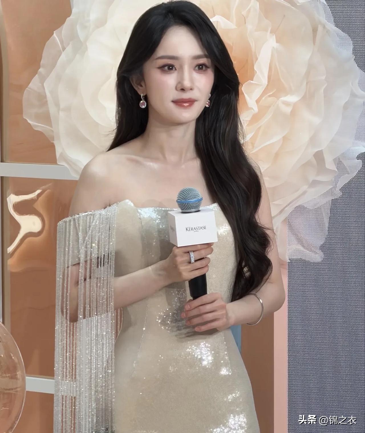 近日杨幂出席活动，她身穿一袭白色流苏长裙，秀发披肩，气质出众，笑容温柔明媚，身材