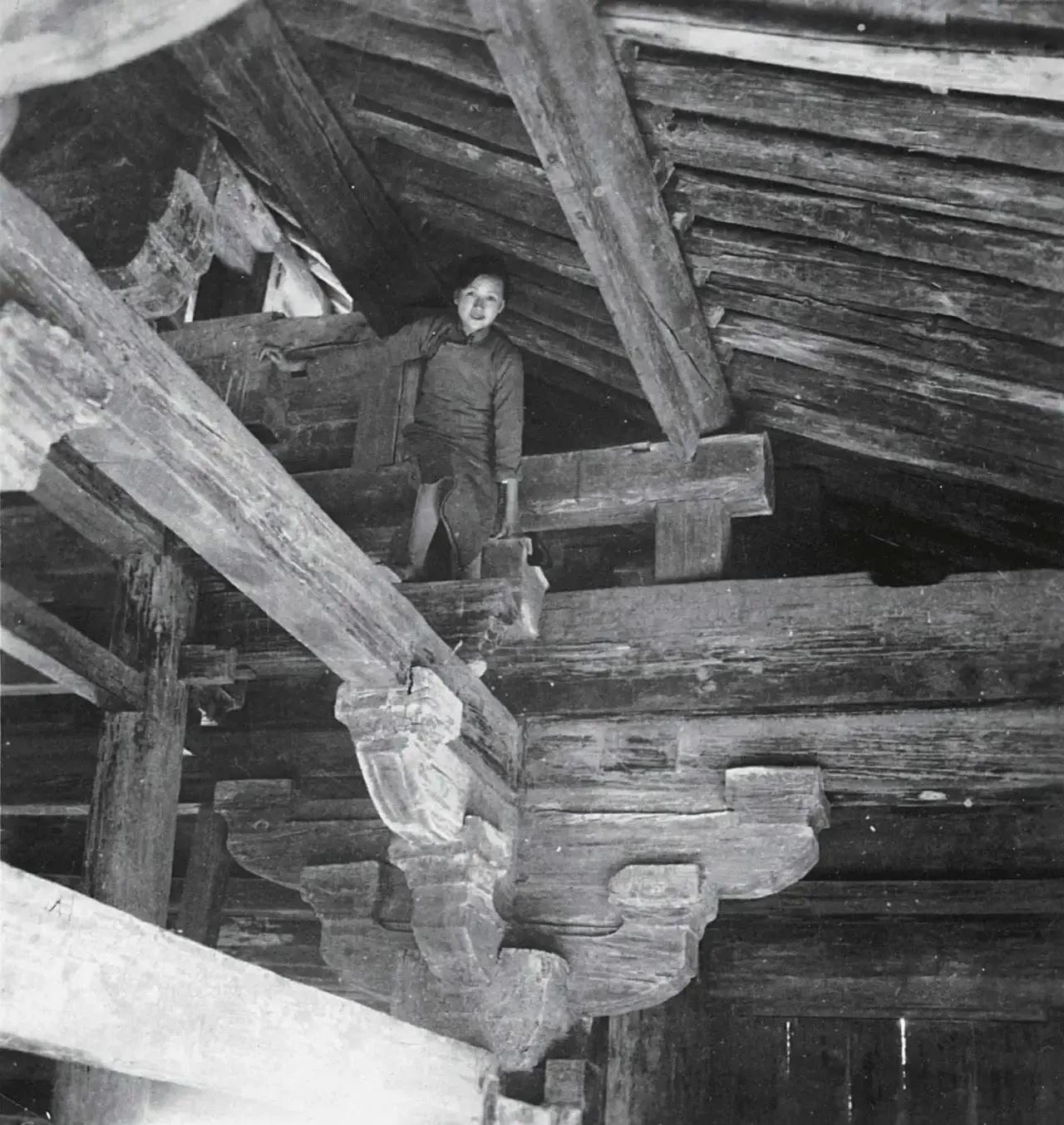 杨澜指着这张照片，问梁从诫：“你母亲穿着旗袍，是怎么爬上这么高的房梁的？梁从诫的