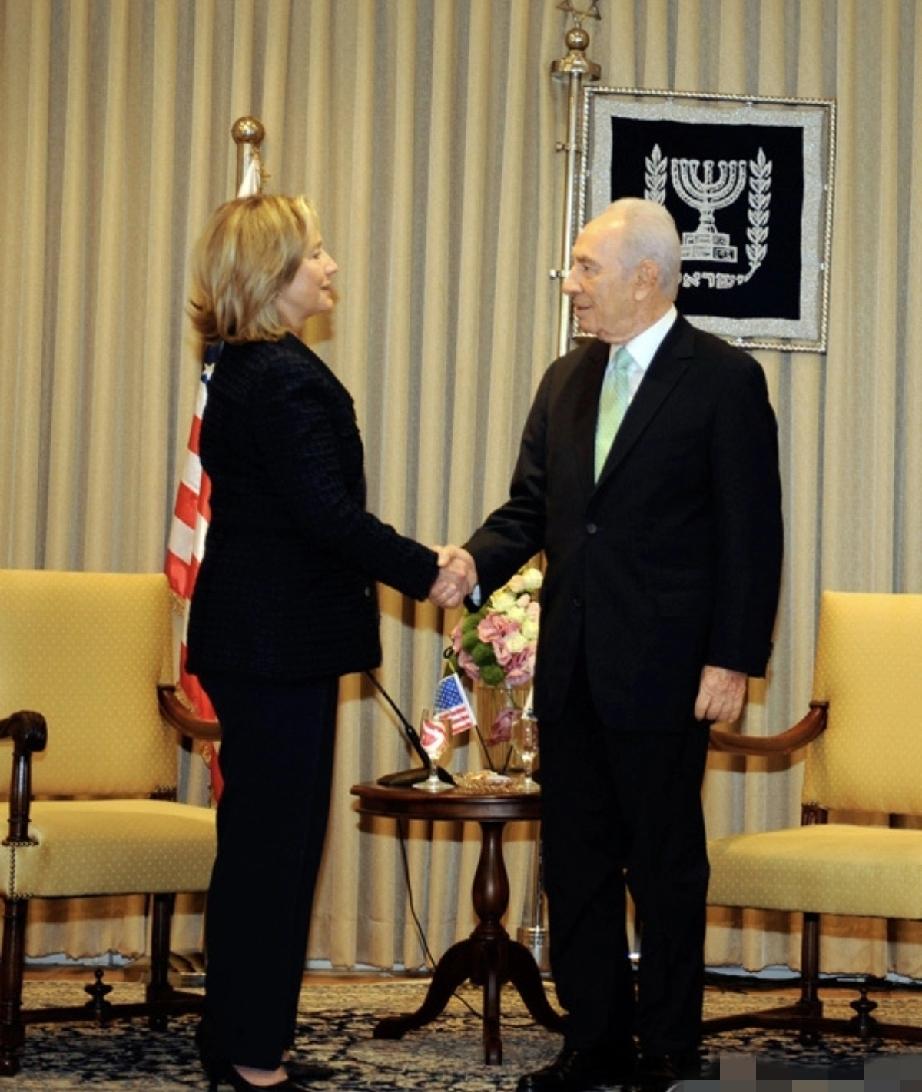 和佩雷斯握手的希拉里，像一位雷厉风行的女领导，佩雷斯的眼神里有一丝诧异：这大妹子