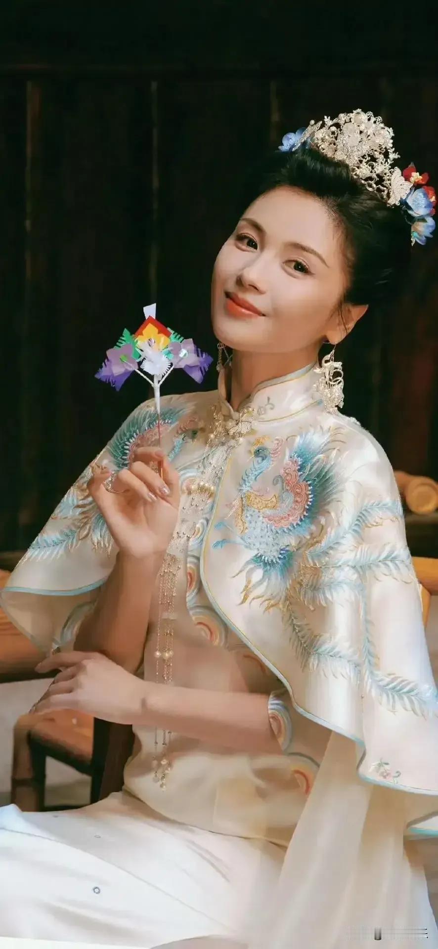 看刘涛这一身中式婚服造型，凤纹披肩精致，发间珠翠灵动，手持小纸鸢浅笑，把东方韵味