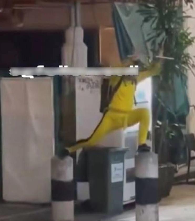 中国教头李宏伟在新加坡街头舞双节棍。59岁的他身着李小龙标志性的黄色紧身运动衫，