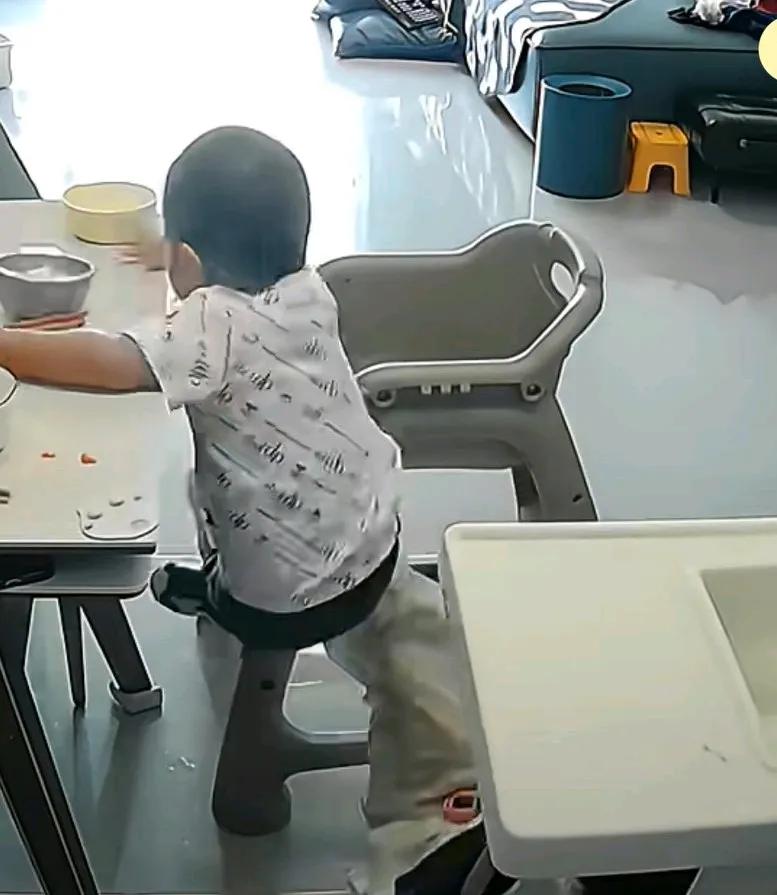 姐姐坐餐椅不小心摔倒，拍下时又把旁边的弟弟一起带倒了，
弟弟正在旁边用筷子吃着东