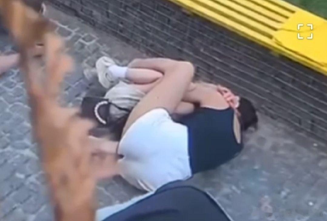 在乌克兰苏梅户外，俄罗斯对空旷的人群发动袭击时，这位妈妈躺在地上，紧紧地抱紧自己