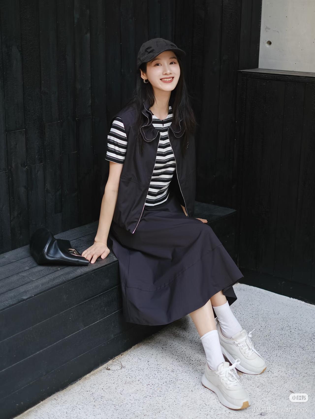 黑衣少女倚木凳，笑靥如花映秋光。