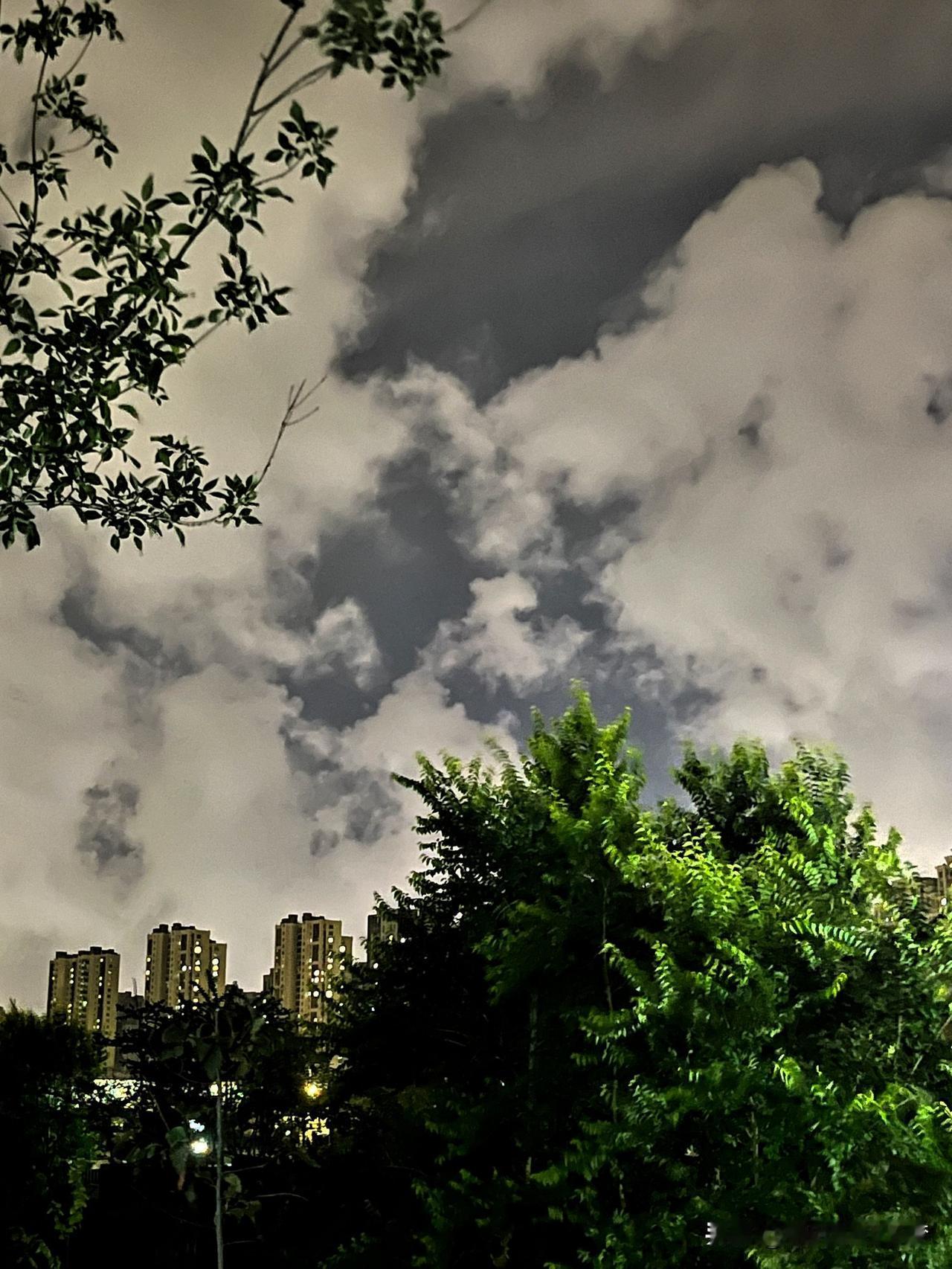 晚上的天空如同一幅美妙的画卷，云朵在夜色中熠熠生辉，绚烂多姿。