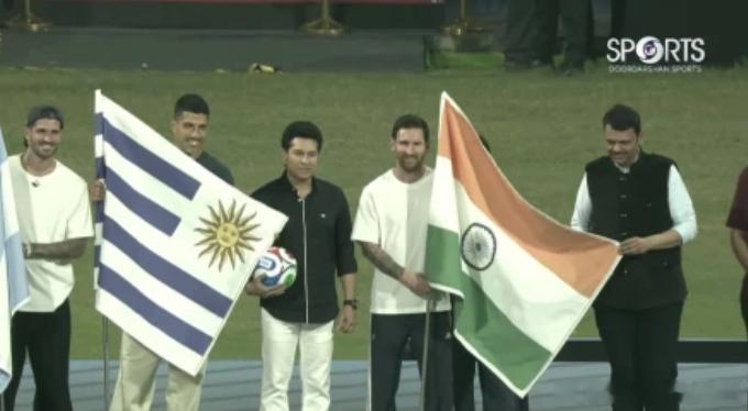 梅西抵达印度行第三站孟买，开球仪式前合影手拿印度国旗画面中，梅西手拿印度国旗，苏