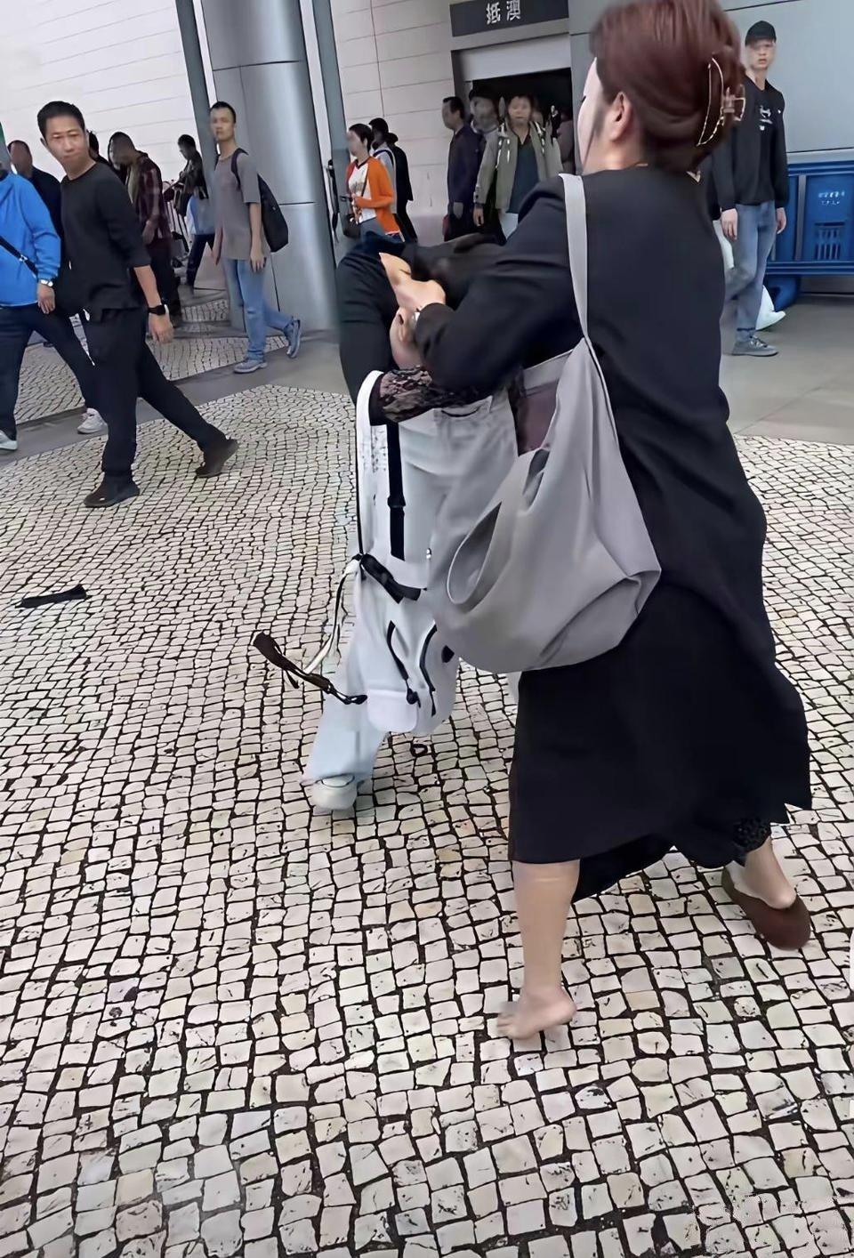大街上，两个女人正撕扯在一起。
黑衣女人步步紧逼，把对方死死按在地上，全程占尽上