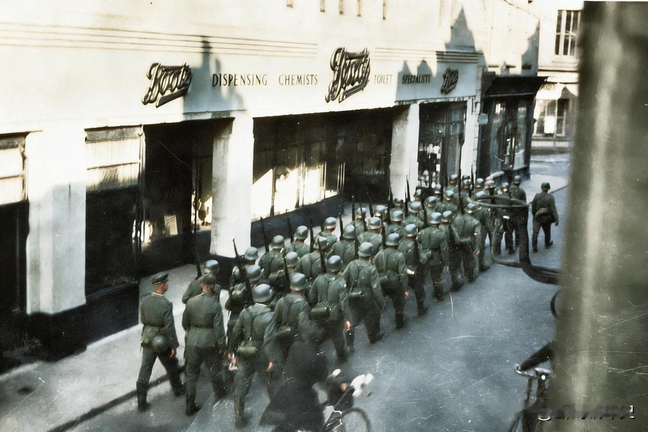 1940年7月1日，泽西岛首府圣赫利尔的街道上，德军士兵列队走过，背景里“Boo
