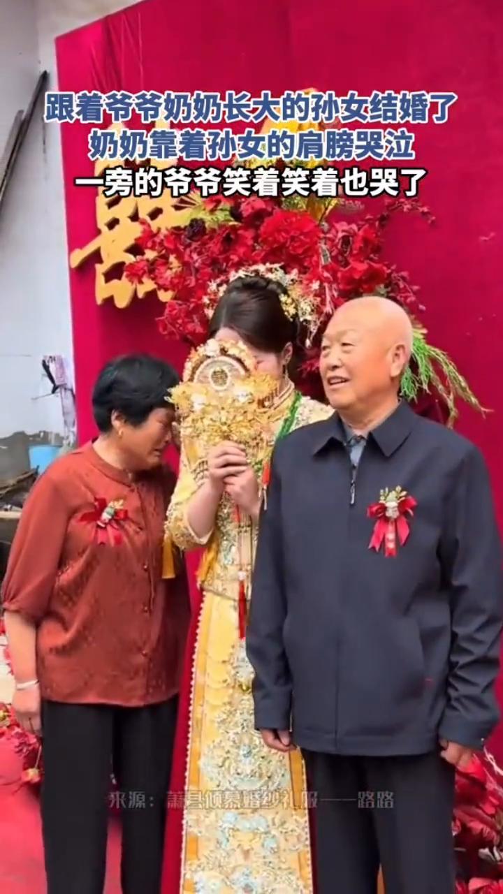 跟着爷爷奶奶长大的孙女结婚了，奶奶靠着孙女的肩膀哭泣，一旁的爷爷笑着笑着也哭了。
