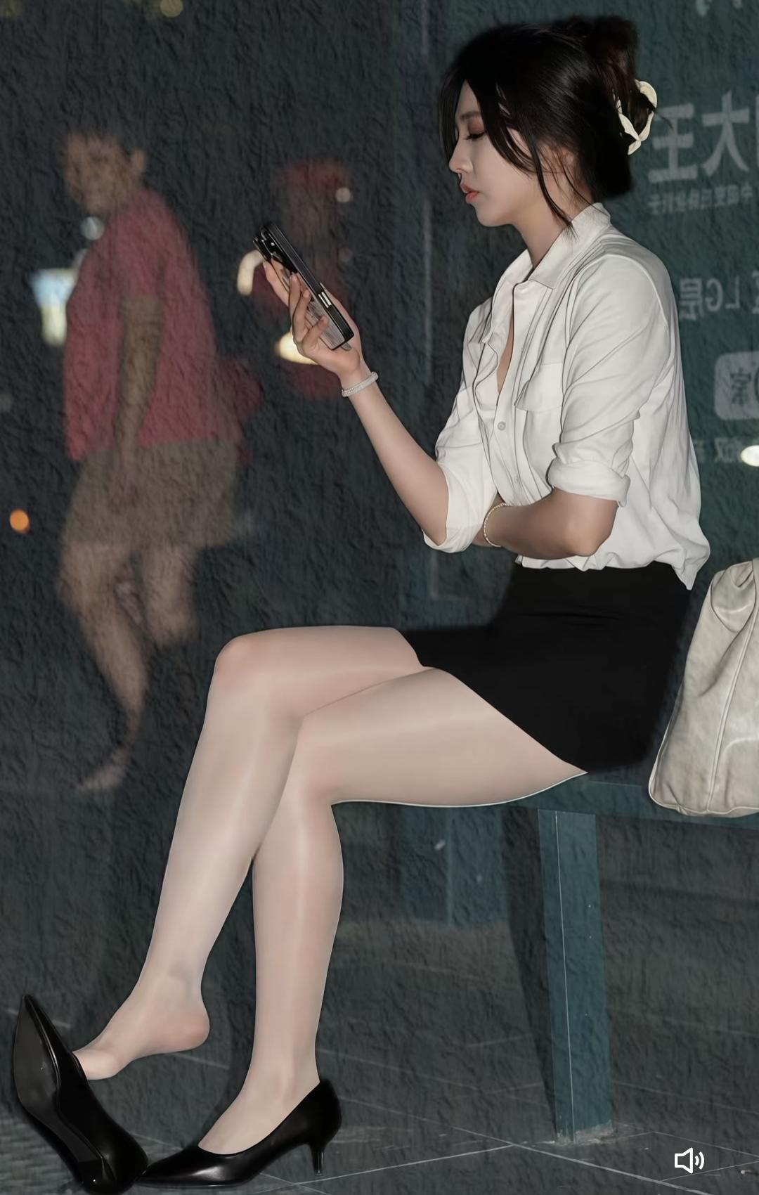 都市白领的优雅瞬间，手机与时尚的完美结合。