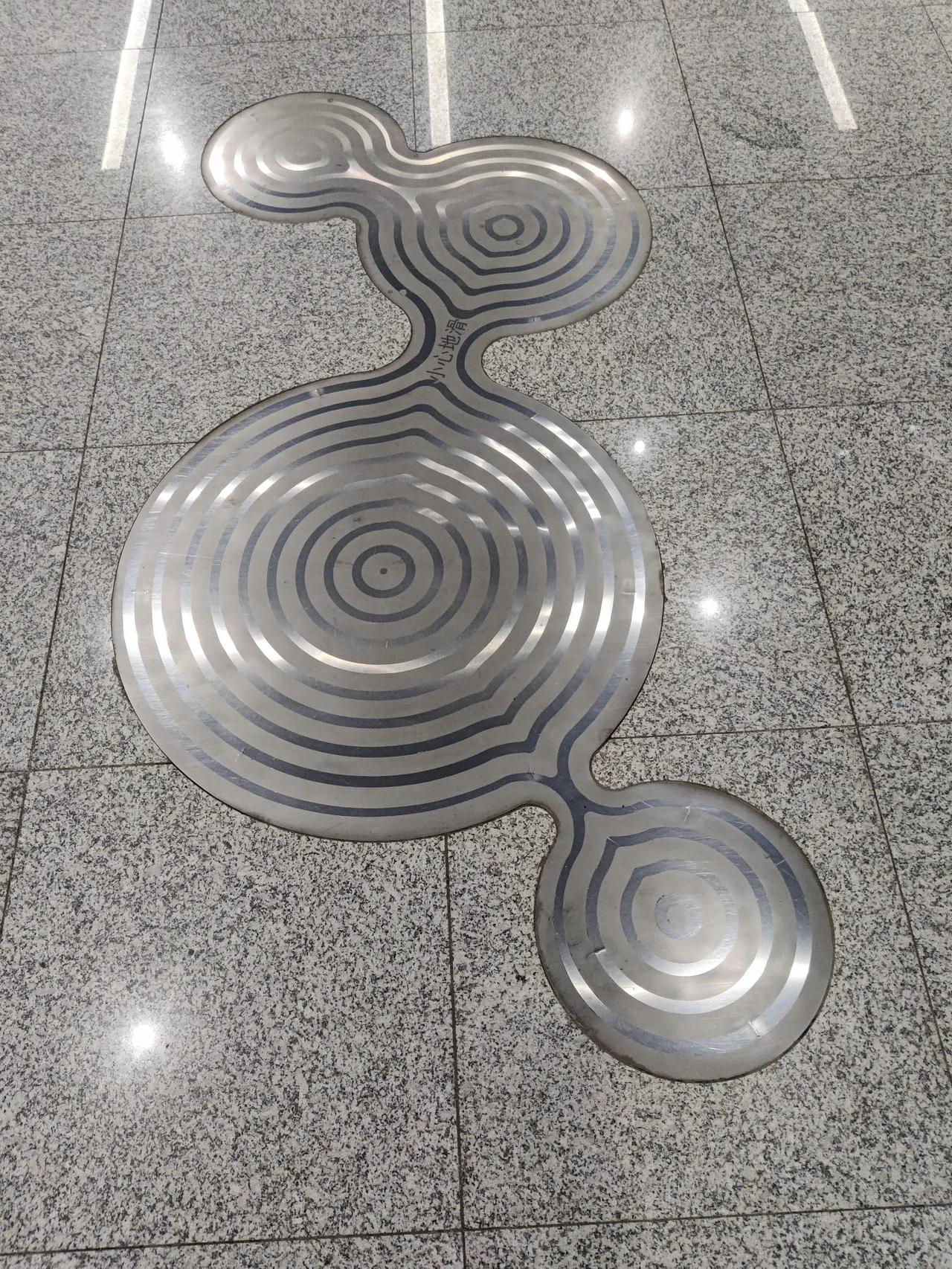 这是什么？北京地铁新宫站，地上的小心地滑
小心地滑，却很滑。
有四个，形状不太一