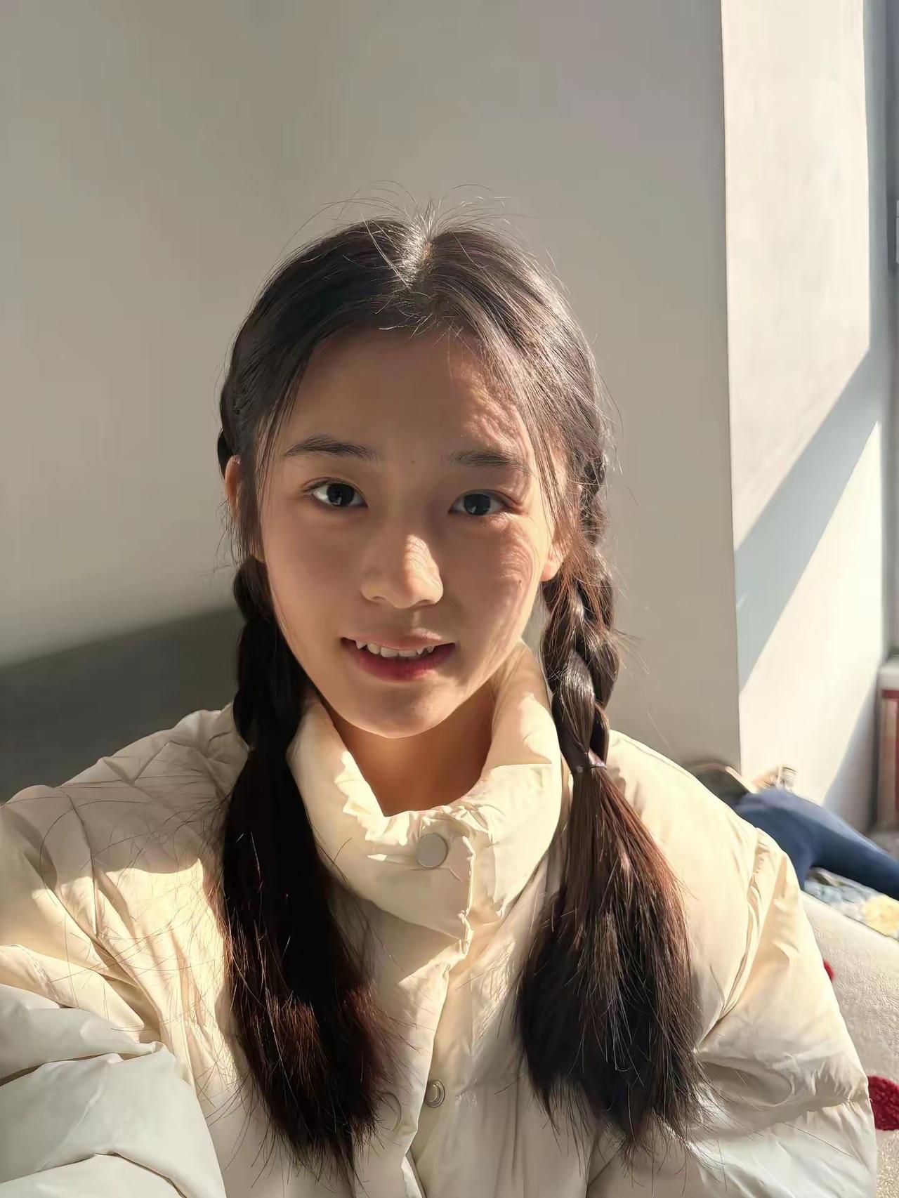 奶乎乎的米白外套，配上双麻花辫，被冬日的阳光温柔笼罩着。一个浅笑，一个眨眼，都是