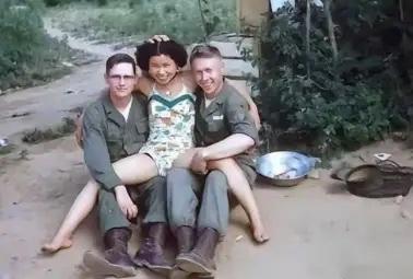 1952年，一名南朝鲜女子给两名美军做完服务后，当着老公的面热情地送大兵们离开。