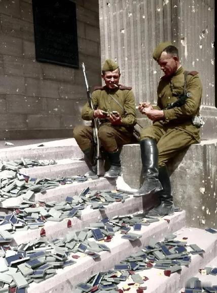 1945年柏林战役后，两名苏联士兵面前丢了一地的德国勋章，二战中德国士兵为了得到