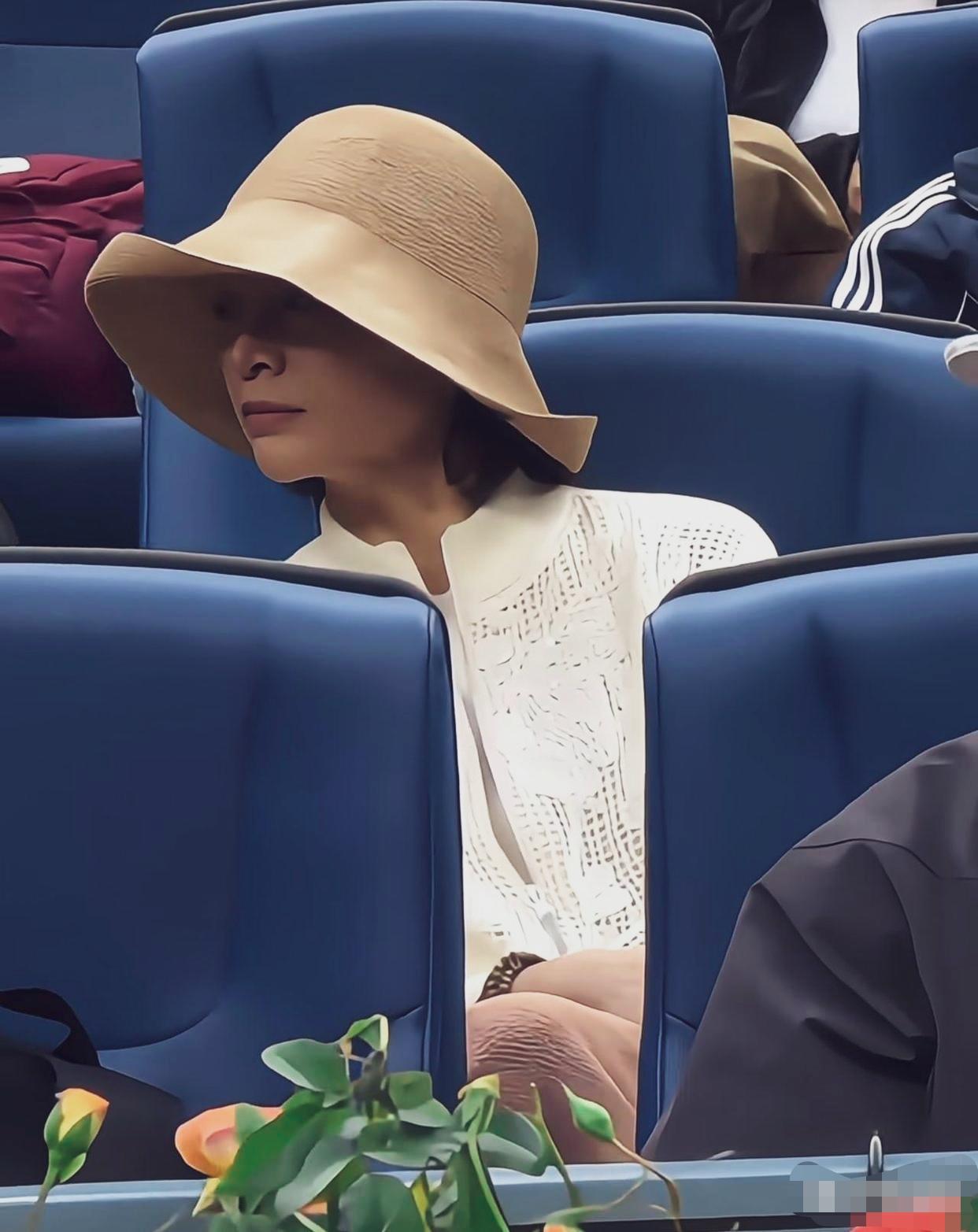 网友在中网赛场看台偶遇董卿拍下的。她头戴浅卡其大檐渔夫帽，配米白色镂空针织上衣，