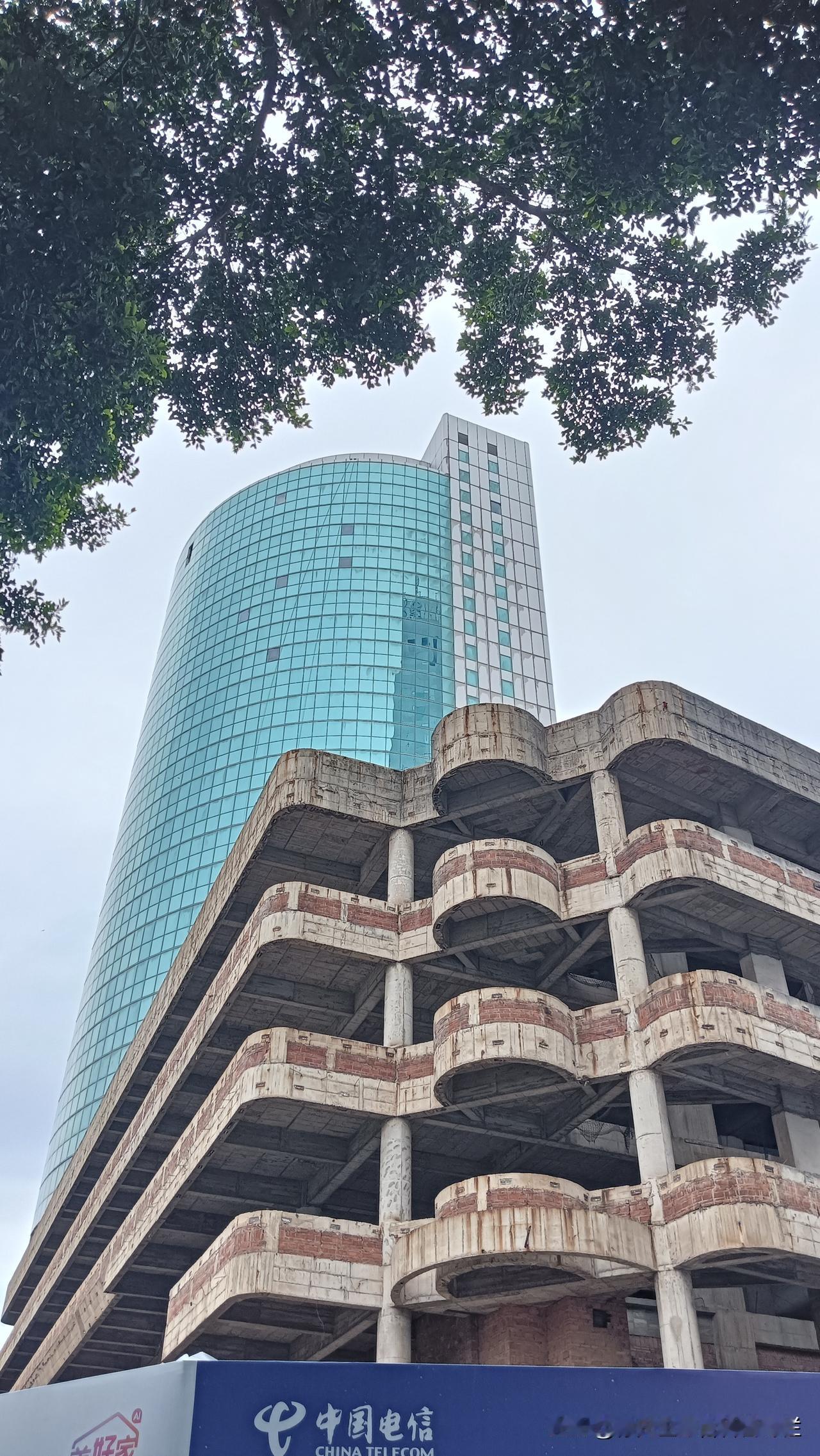 江门活化工程｜江门市电信大楼旁边烂尾楼
荒废多时烂尾楼，
把遮羞布除下，
是否真