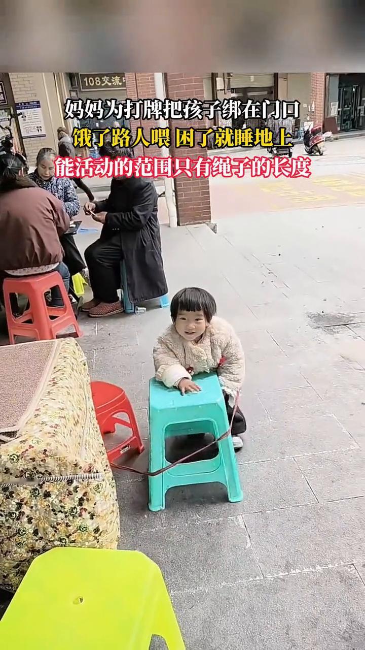 妈妈为打牌把孩子绑在门口，饿了路人喂，困了就睡地上。
能活动的范围只有绳子的长度