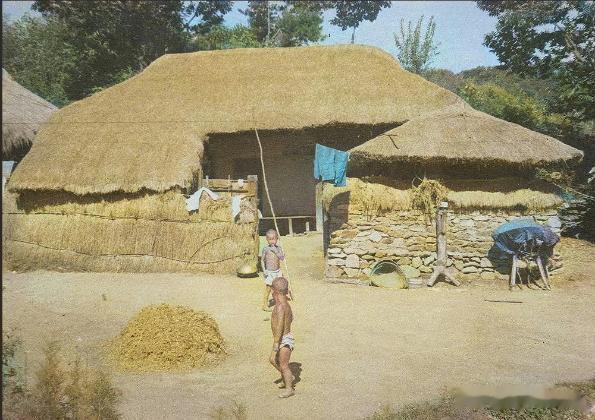 60年代首都汉城近郊的泥墙草屋下，男孩子赤着上身，这时南朝鲜是世界最贫穷的国家之