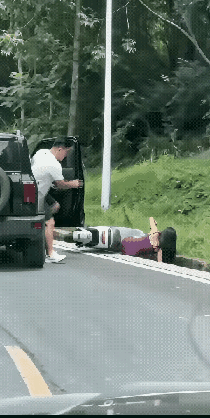 女子骑电动车翻倒在路边。开车男子下车主动将女子扶起来。女子反手就是一耳光。好心没