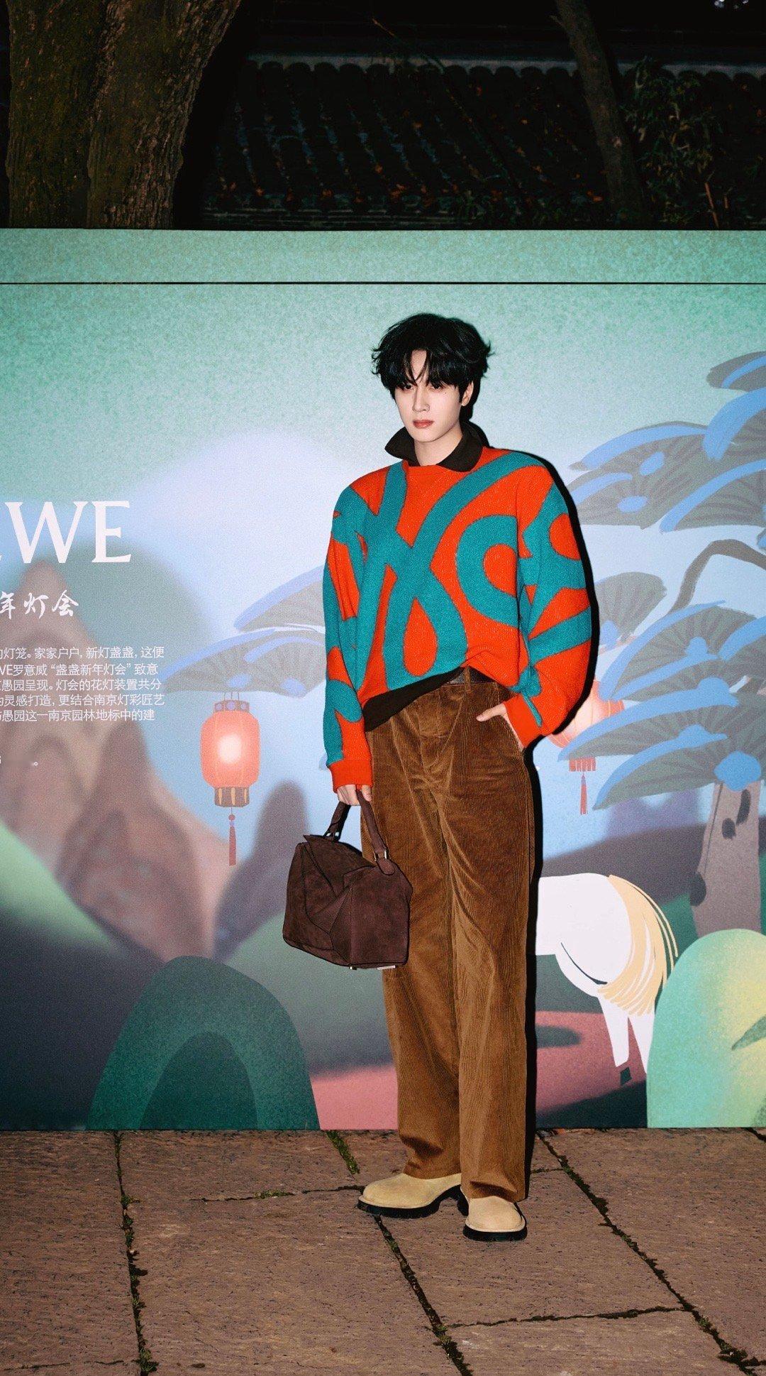 展轩出席LOEWE盏盏新年灯会活动图集，身着线条涂鸦针织衫搭配灯芯绒长裤，手提品