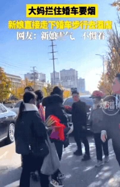 江苏一新娘坐婚车去酒店，结果，途中被一群大妈拦住。
大热天里几个人捂得严严实实，