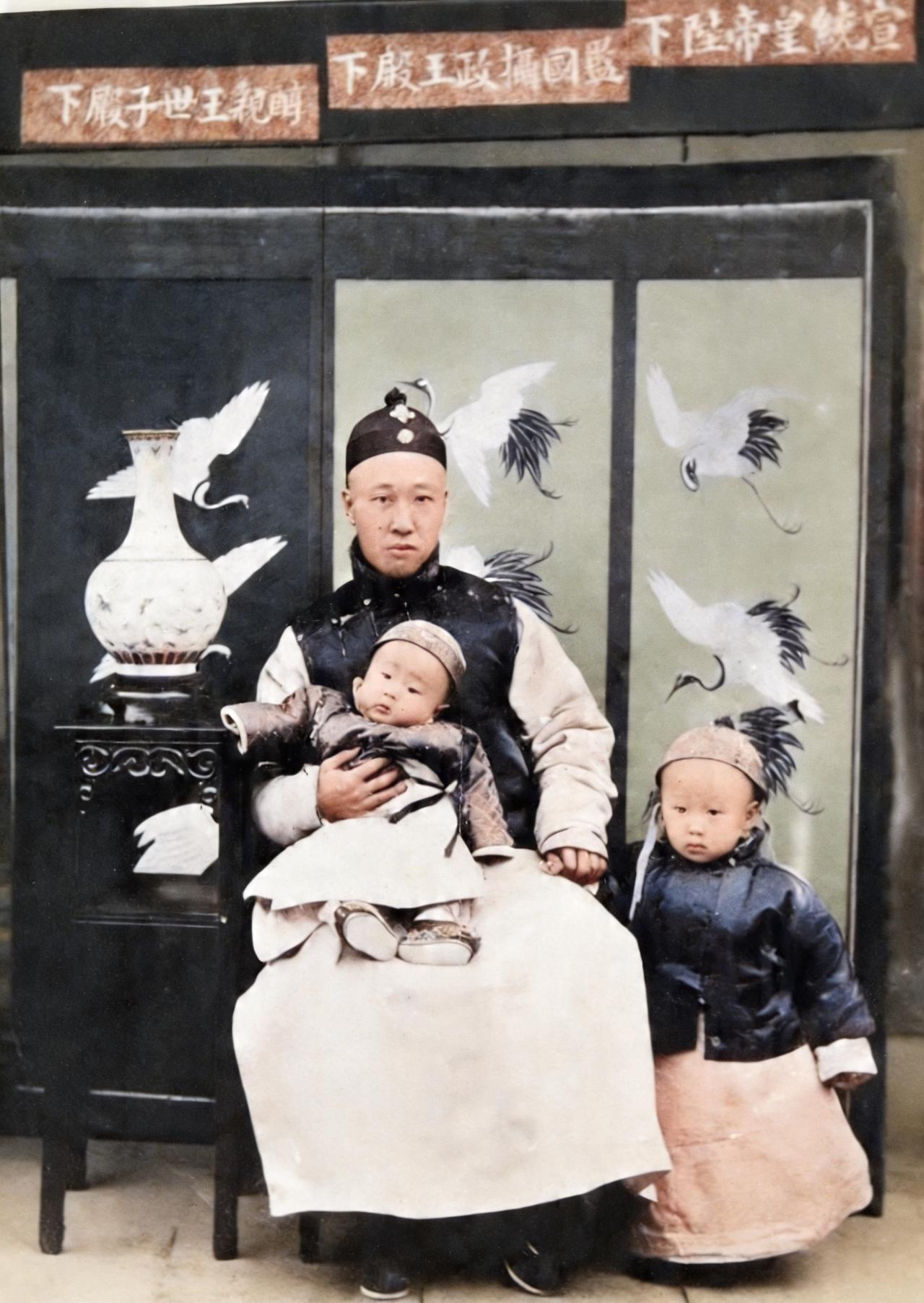 这是一位父亲与两个儿子。这父子仨曾是中国身份与地位最高的人物。照片的上面贴了三张