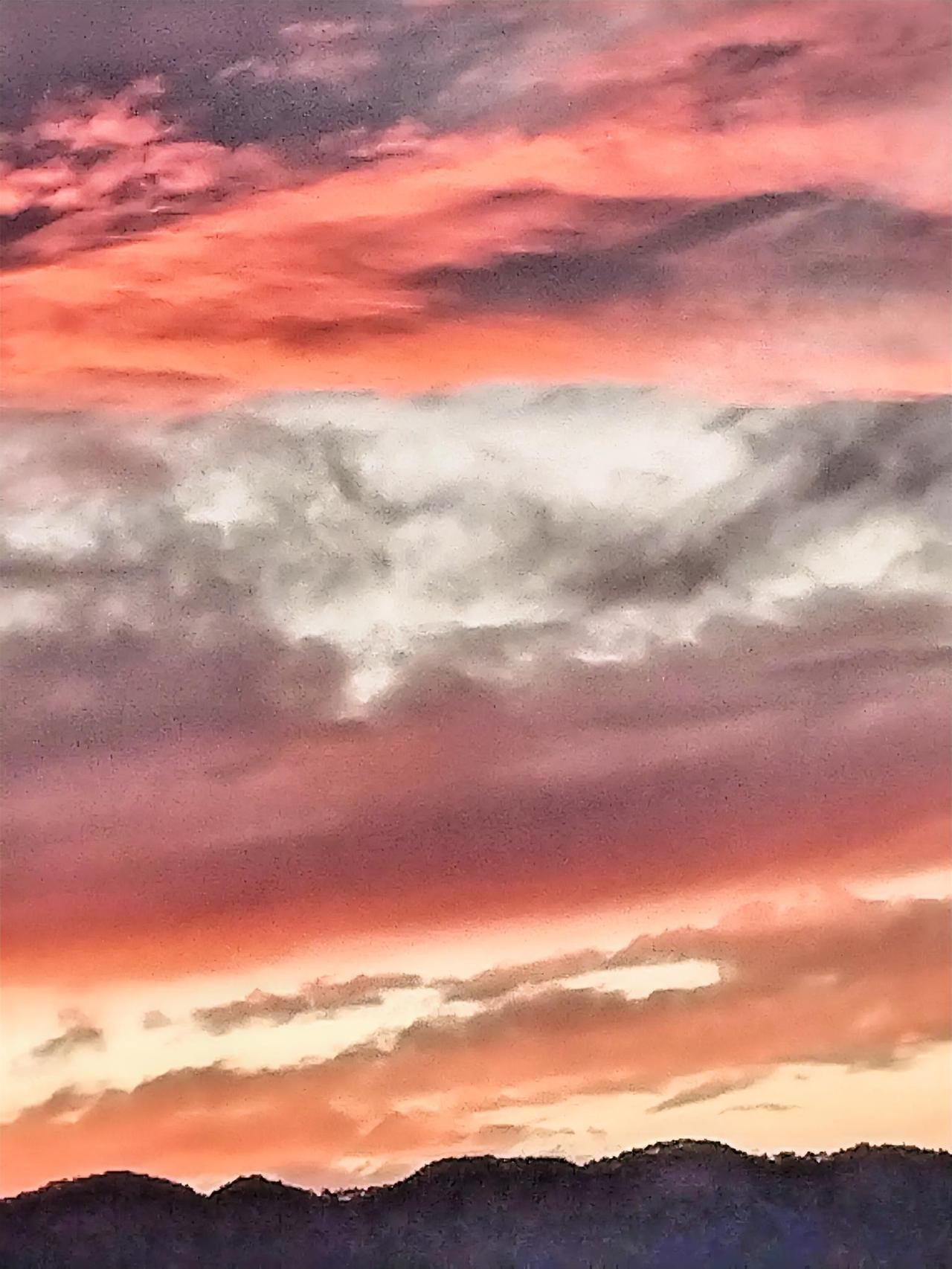 日落时分，云海翻滚，美不胜收。站在山顶，我被眼前这壮丽的天空画卷深深震撼。那翻滚