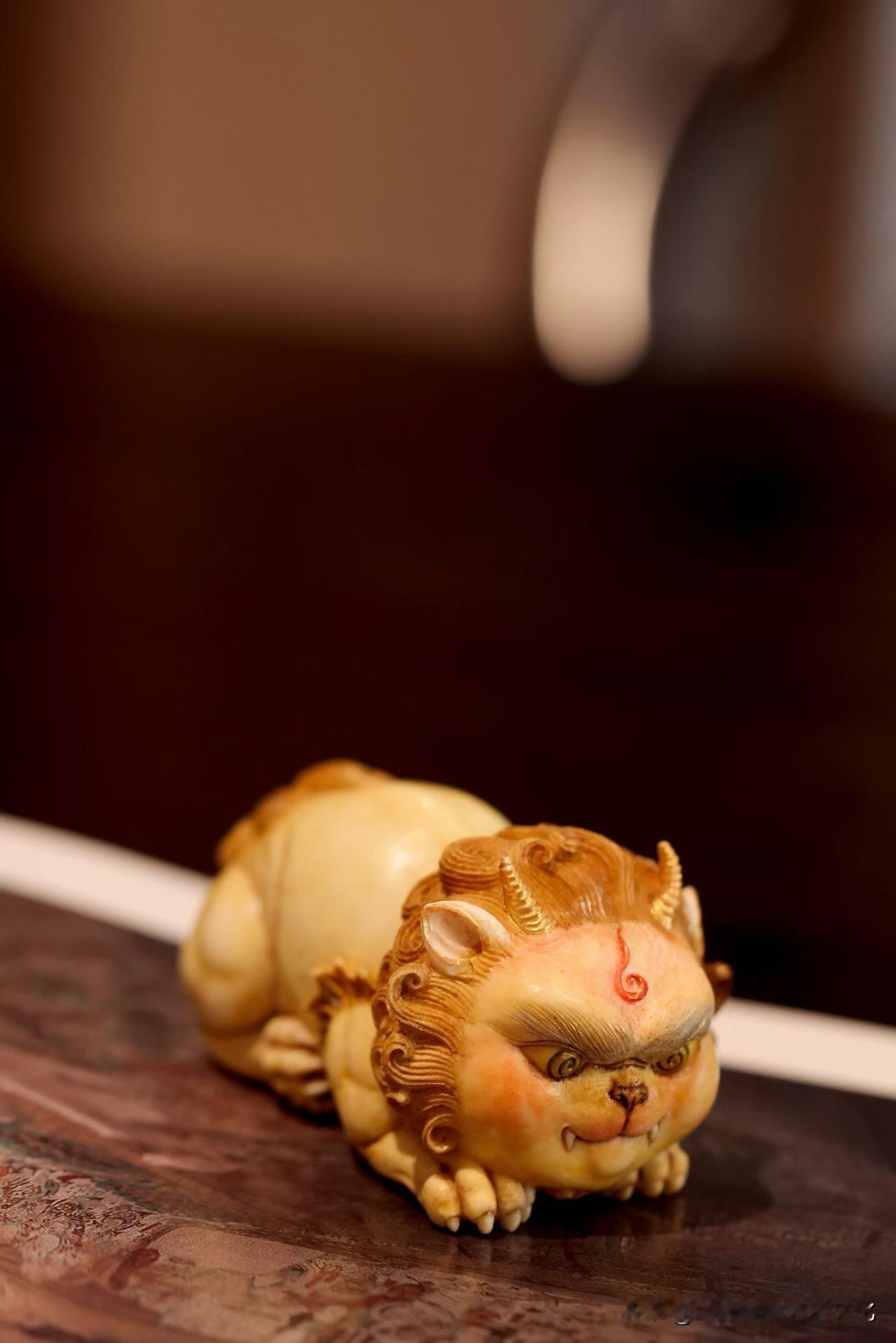 这只狻猊，不威，反而有点“乖”。

鹿角温润，色泽带着岁月的暖意，
小小一尊，趴