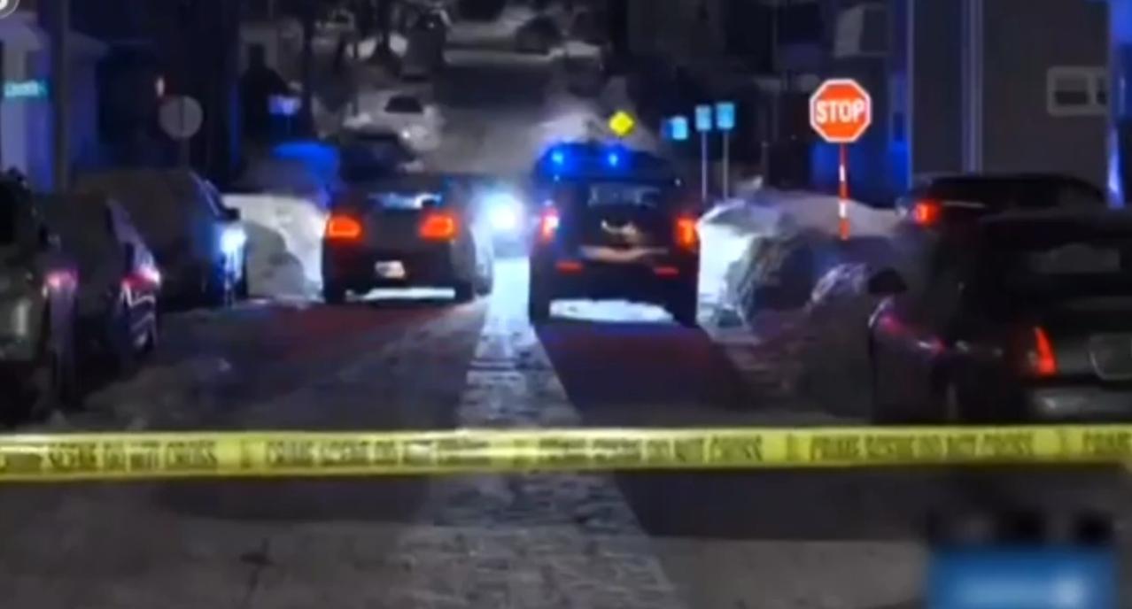 美国多地深夜突发枪击事件，警灯在积雪覆盖的街道上闪烁，黄色警戒线封锁了现场。警方