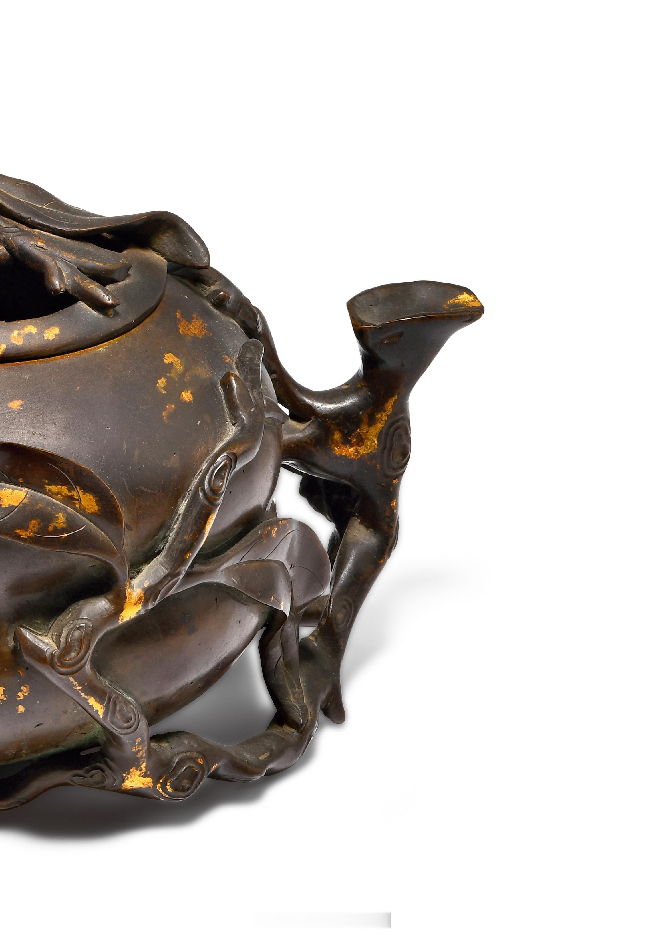 清乾隆 铜点金桃型熏炉此器造型为一个横卧的寿桃，在桃子的蒂端有连枝，其粗枝拱起形