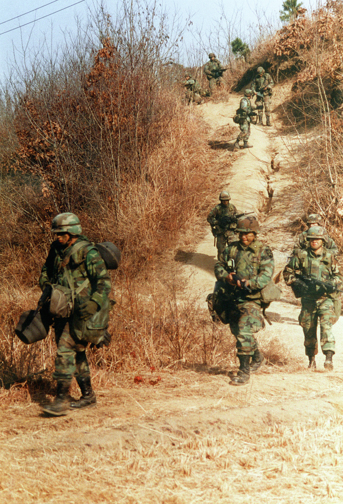 1991年，美国与韩国士兵在韩国台风靶场的实弹演习中执行巡逻任务。 