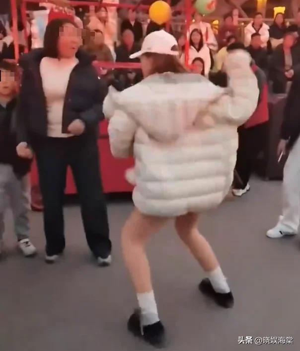 浙江某户外景区。
女子抱着小狗观看表演，狗去舔舐邻座的男孩。男孩妈妈问:“麻烦能