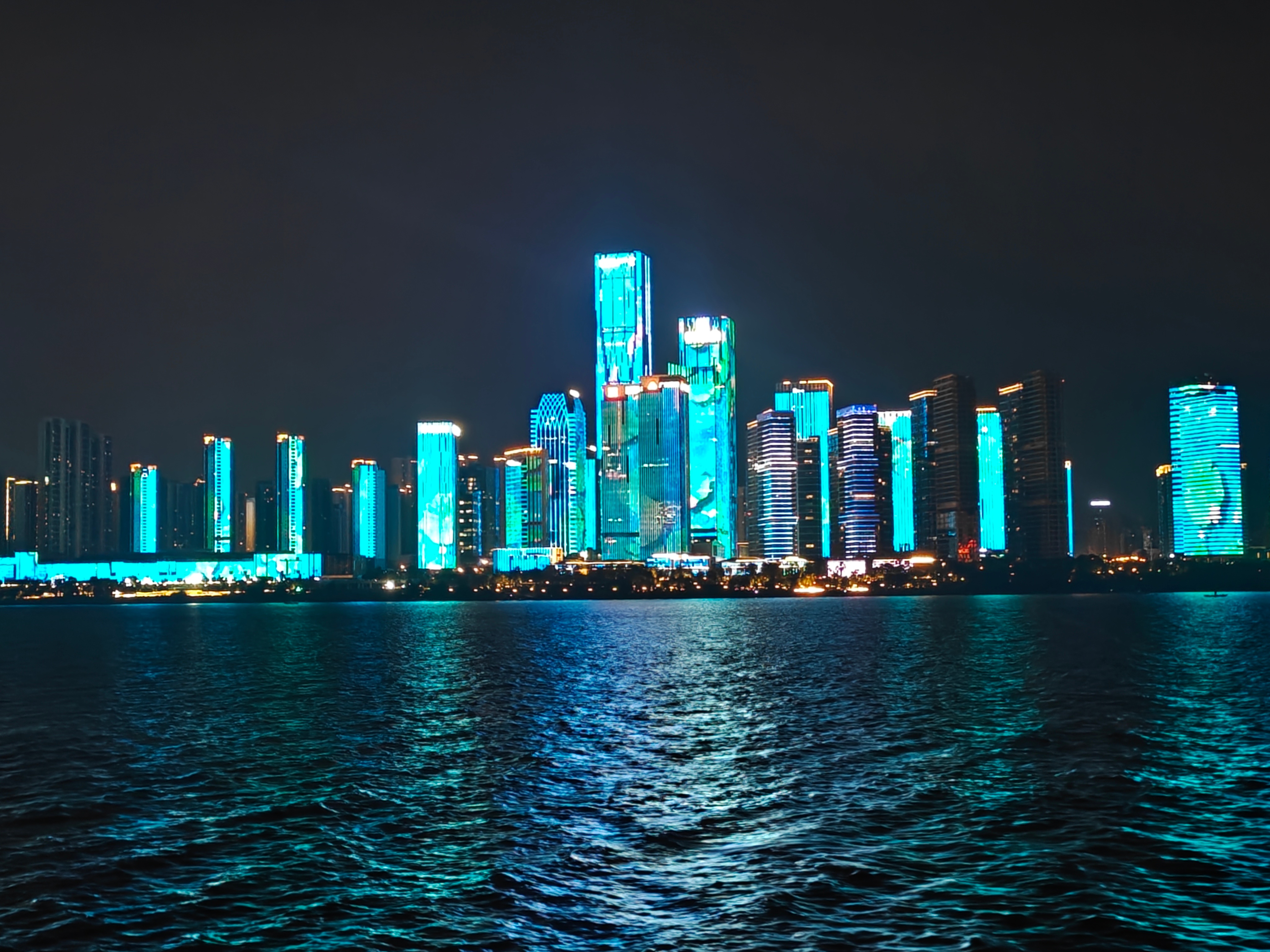 乘船夜游湘江，晚风漫过江面，城市灯火在水波上轻轻摇晃。一边是高楼楼宇流转变幻的灯