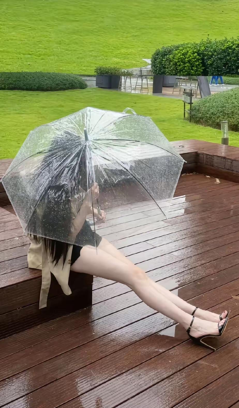 雨天在公园草坪撞见个好看姑娘撑着透明伞，这伞可太有说法了。细雨隔着一层塑料挡着，