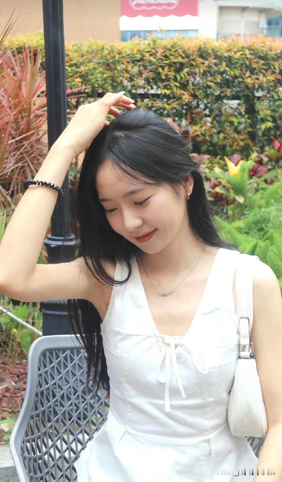 夏日清新穿搭，白色连衣裙与绿植相映成趣，轻松惬意。