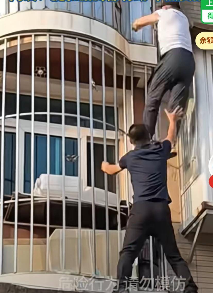 老人被困在户外栏杆上，突然掉落，被男子及时接住，
看的人心惊肉跳，
男子真的是有