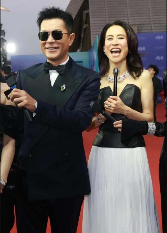 古天乐和宣萱手牵着手一起现身颁奖典礼，古天乐里面穿了一件白色衬衣，外面套着黑色的