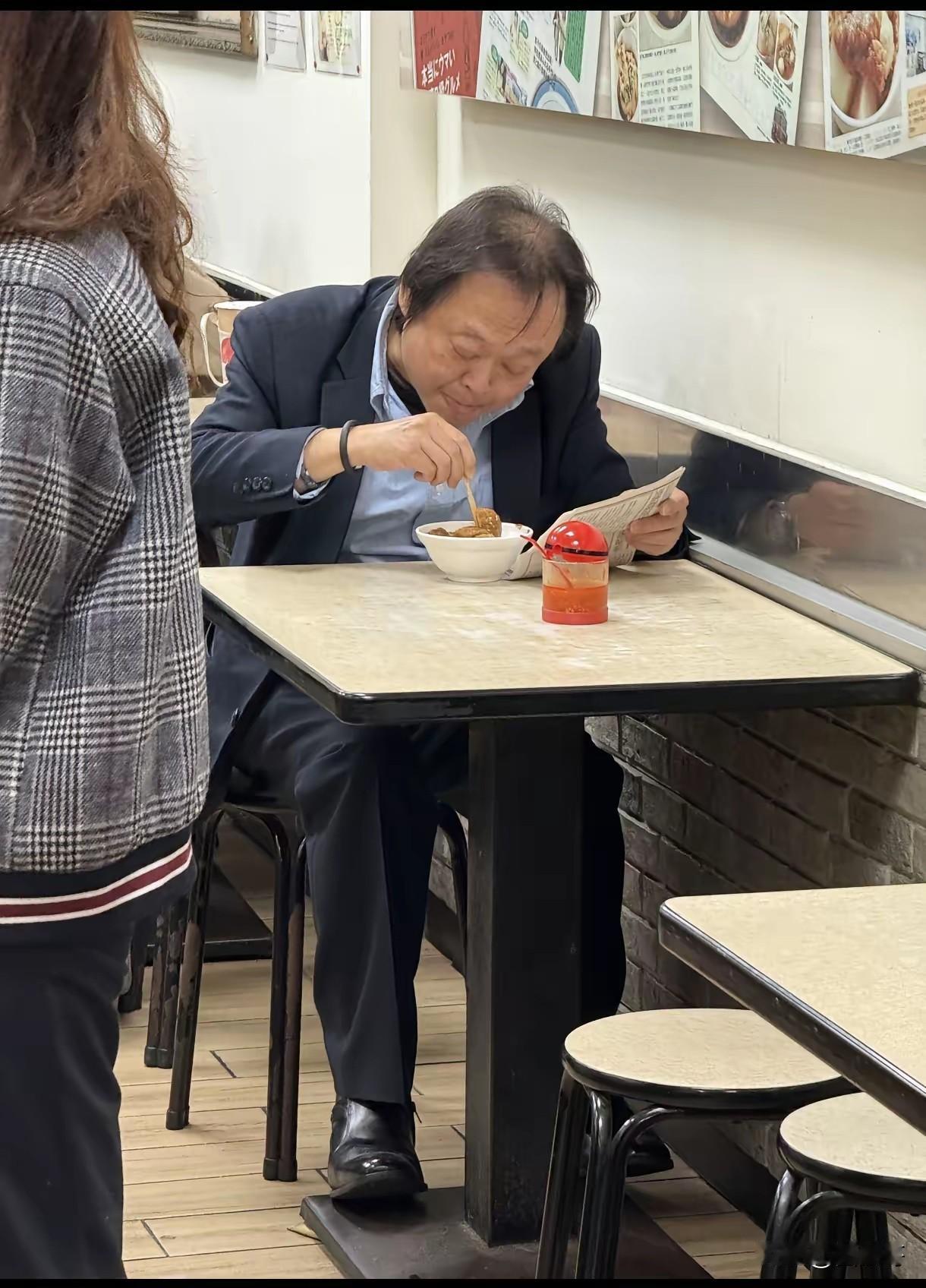 有岛内网友在小吃店偶遇王世坚，他一身西装、皮鞋锃亮，正独自聚精会神地享受美食，左