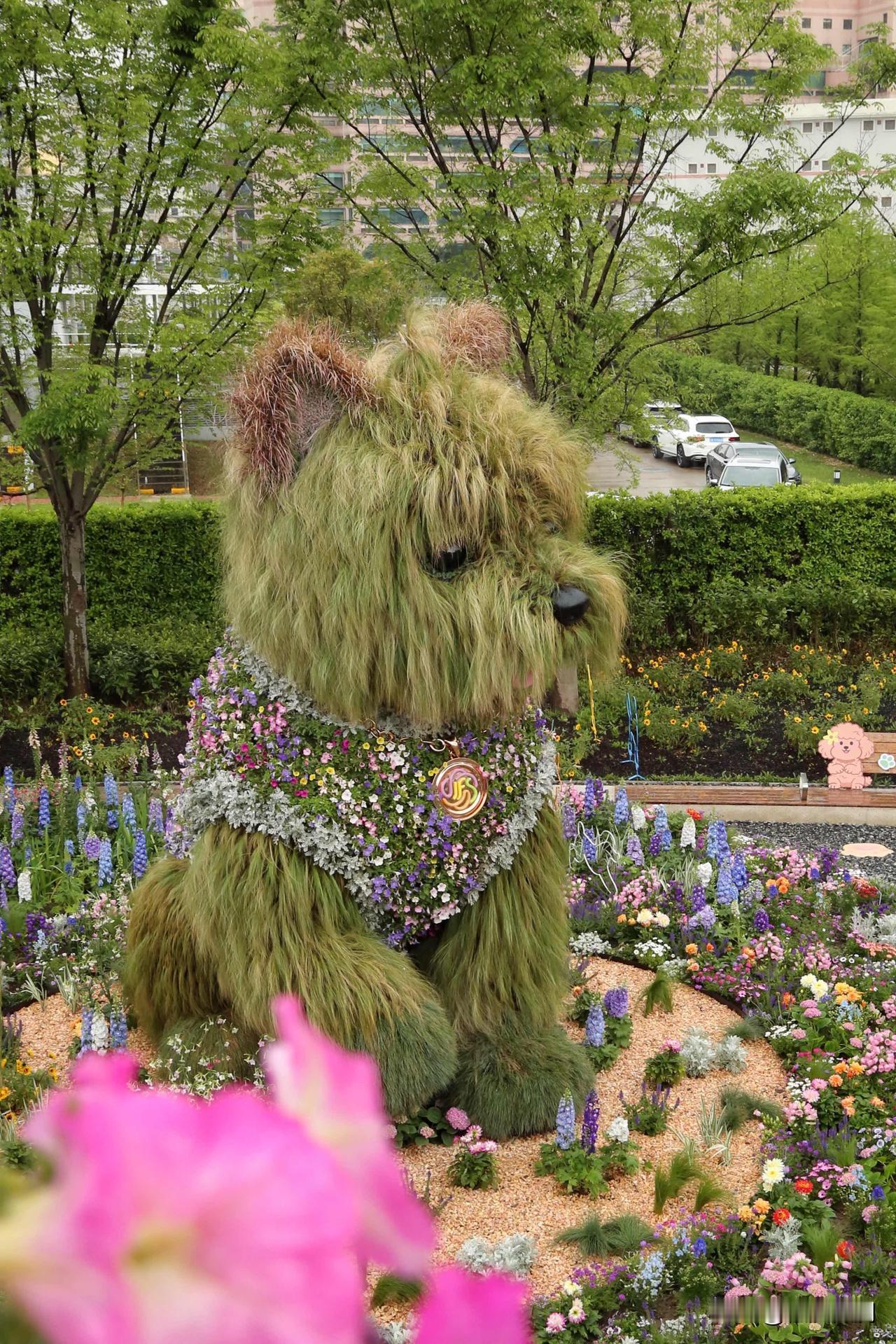 一只巨大的西高地宝宝，用草做出了顺毛感，胸前用鲜花织成的小围兜非常精致漂亮，这是
