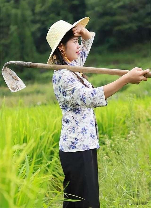 在和煦的阳光下

这位乡村美妇

犹如一幅动人的画卷

她那结实的身板

戴着草