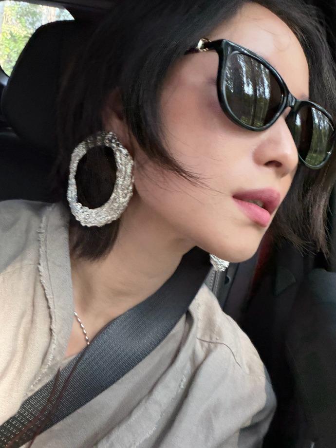 倪妮补一个放学合集倪妮晒出车内放学九宫格合集，黑框墨镜配上超大圆环耳饰，简单的浅