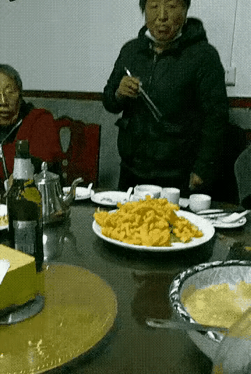 大娘太喜欢这盘菜了，她干脆起身围着活动圆桌追踪这盘菜，好心的食客怕她摔倒，迅速稳