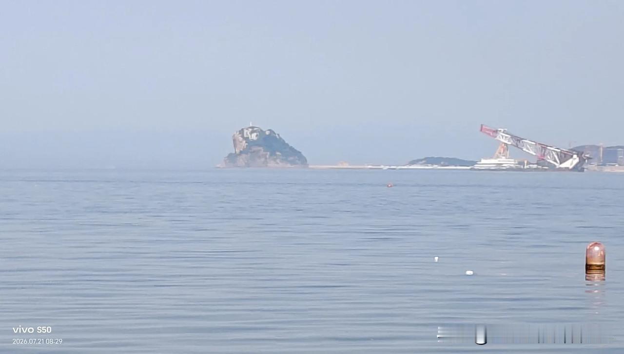 大连金蟾岛的远景。放大去看，它宛如一只巨型蝉虫静卧于海面，那两只圆鼓鼓的眼睛凝视